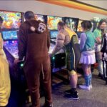 people in costumes playing arcade games