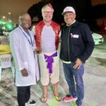 three men standing and smiling in costumes